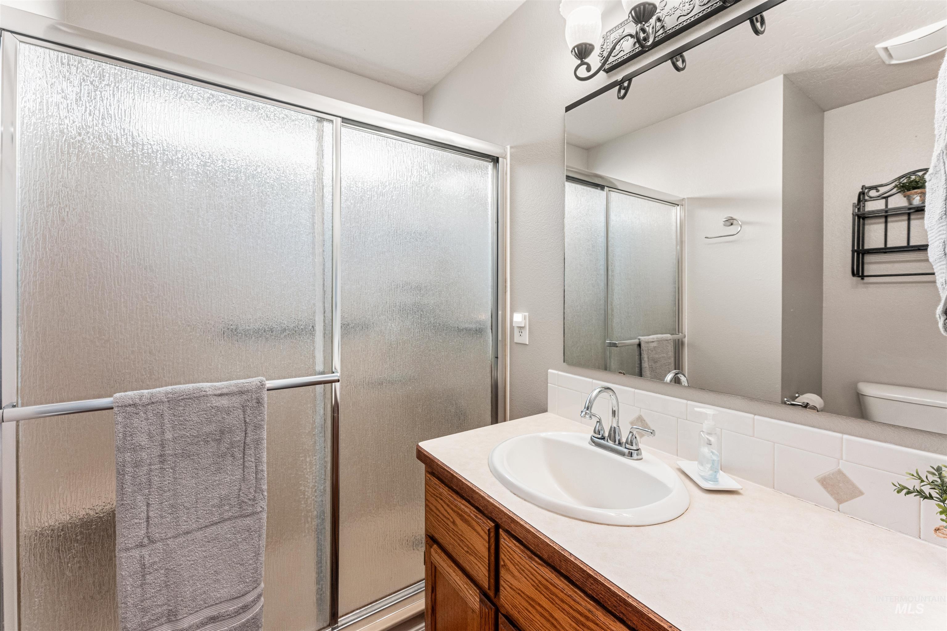 Full bath with vanity and a shower stall