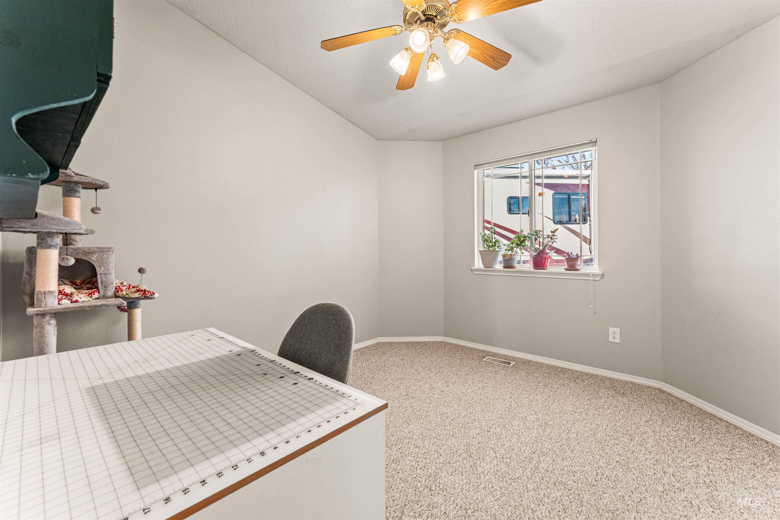 Carpeted office featuring lofted ceiling and ceiling fan