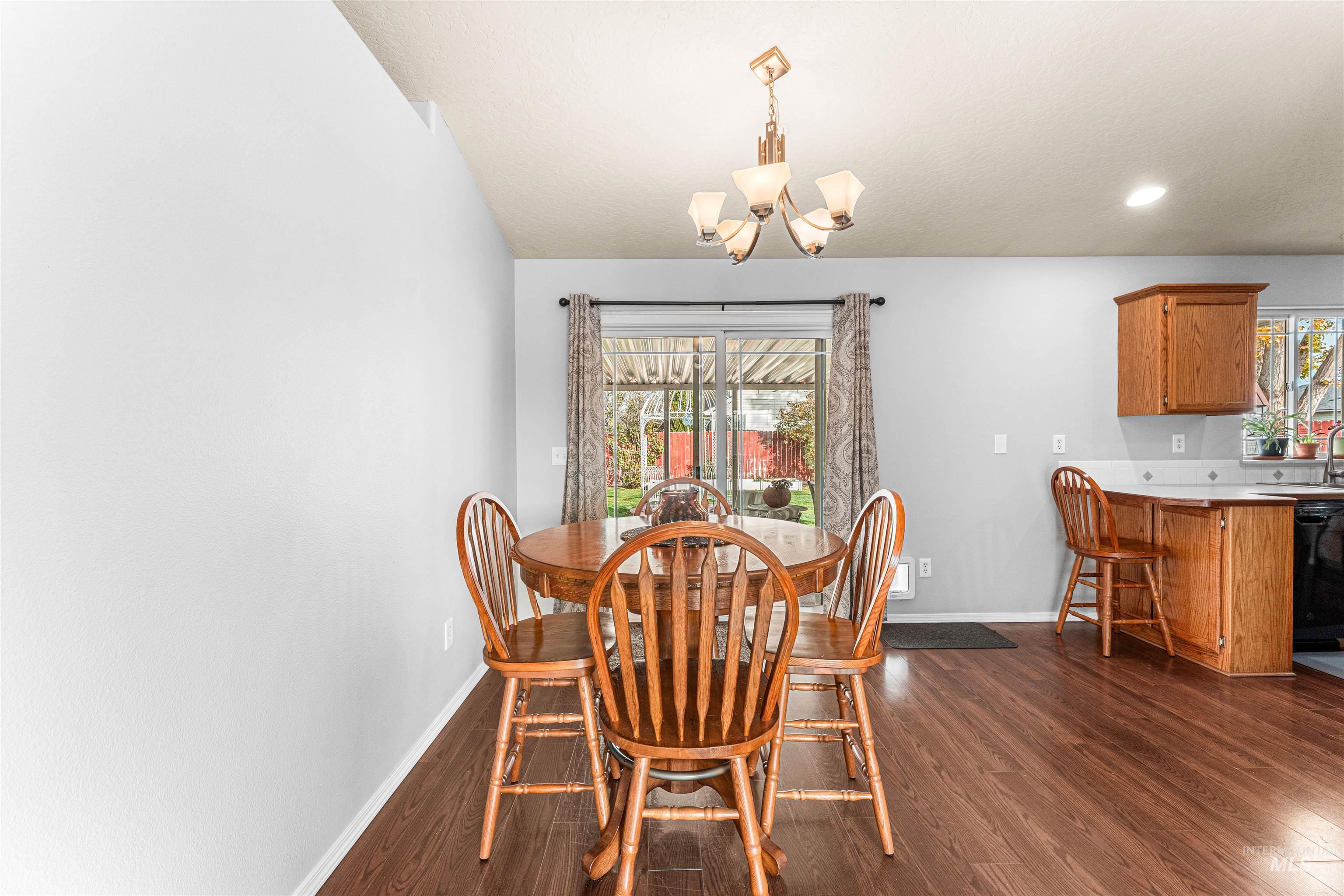 Dining space with dark wood-style floors, a chandelier, and recessed lighting