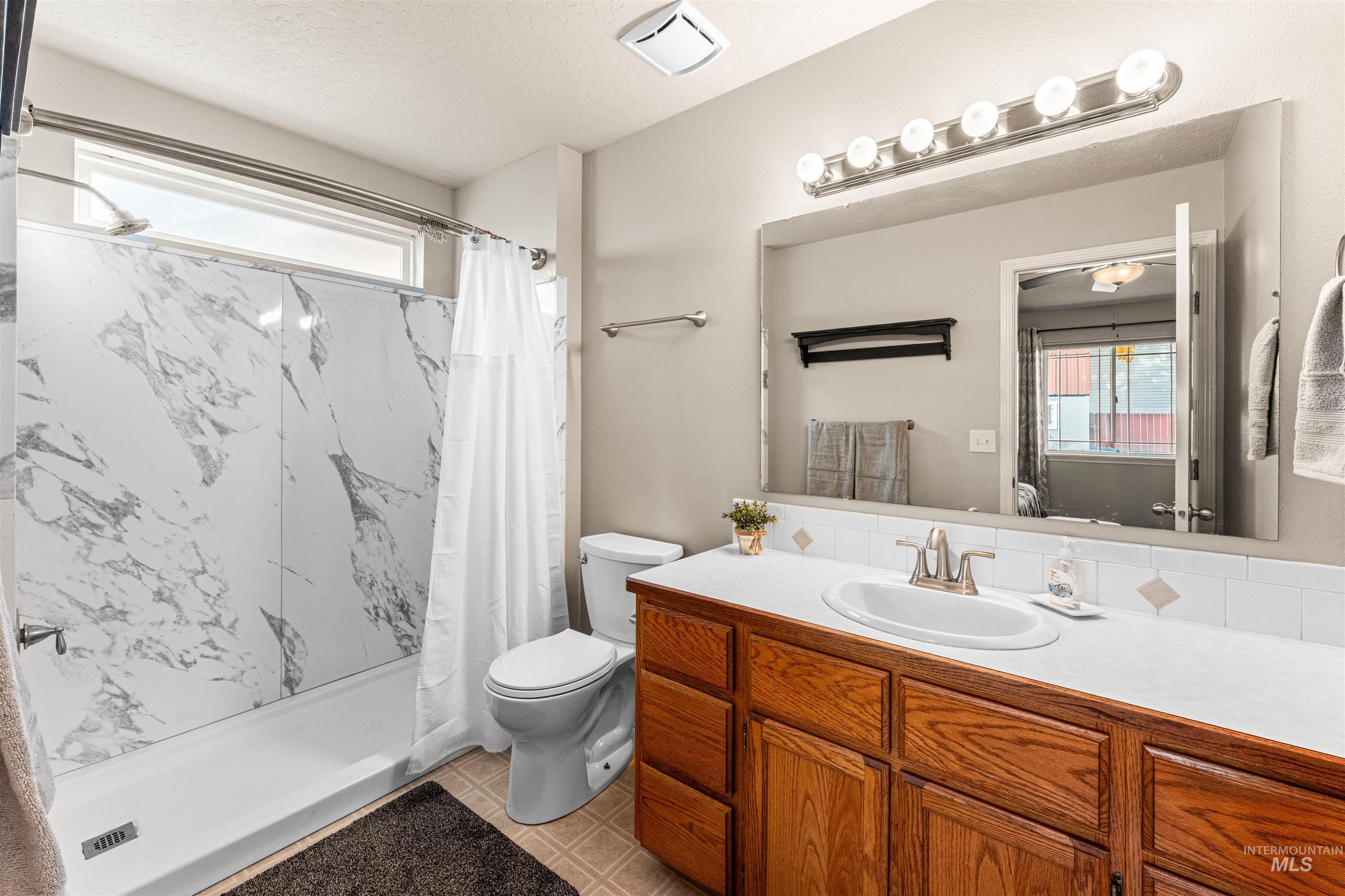 Bathroom with a marble finish shower, vanity, and a textured ceiling