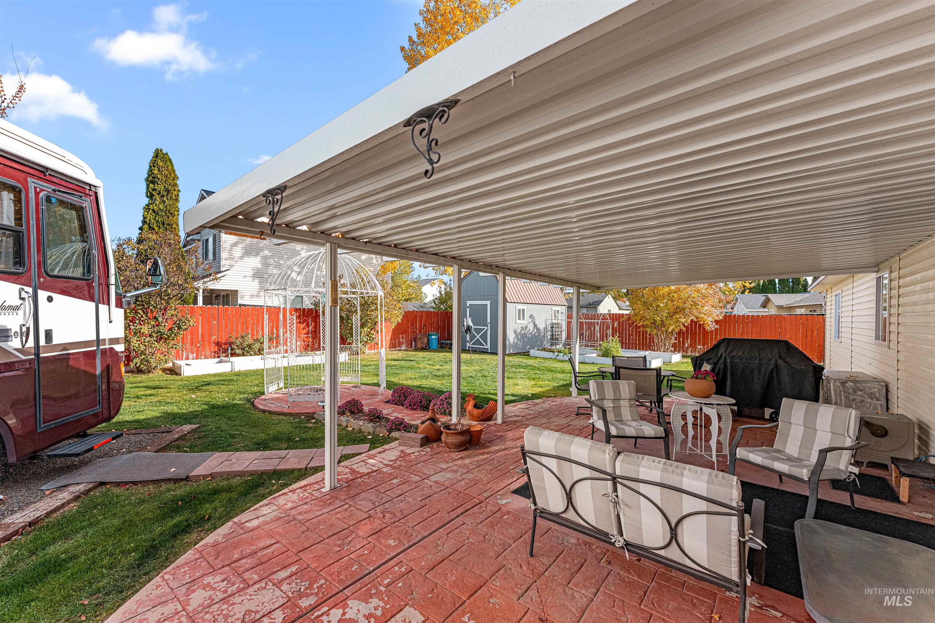 Fenced backyard featuring a patio, a storage shed, area for grilling, and outdoor dining space