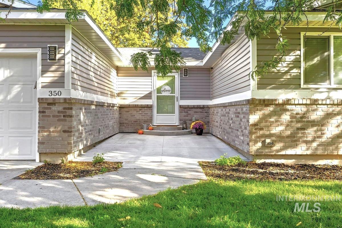 Entrance to property featuring brick siding and a garage