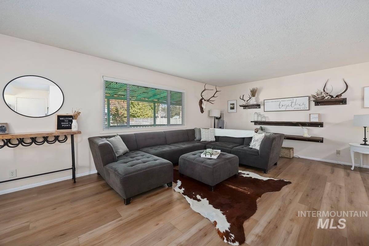 Living area featuring light wood-type flooring and a textured ceiling