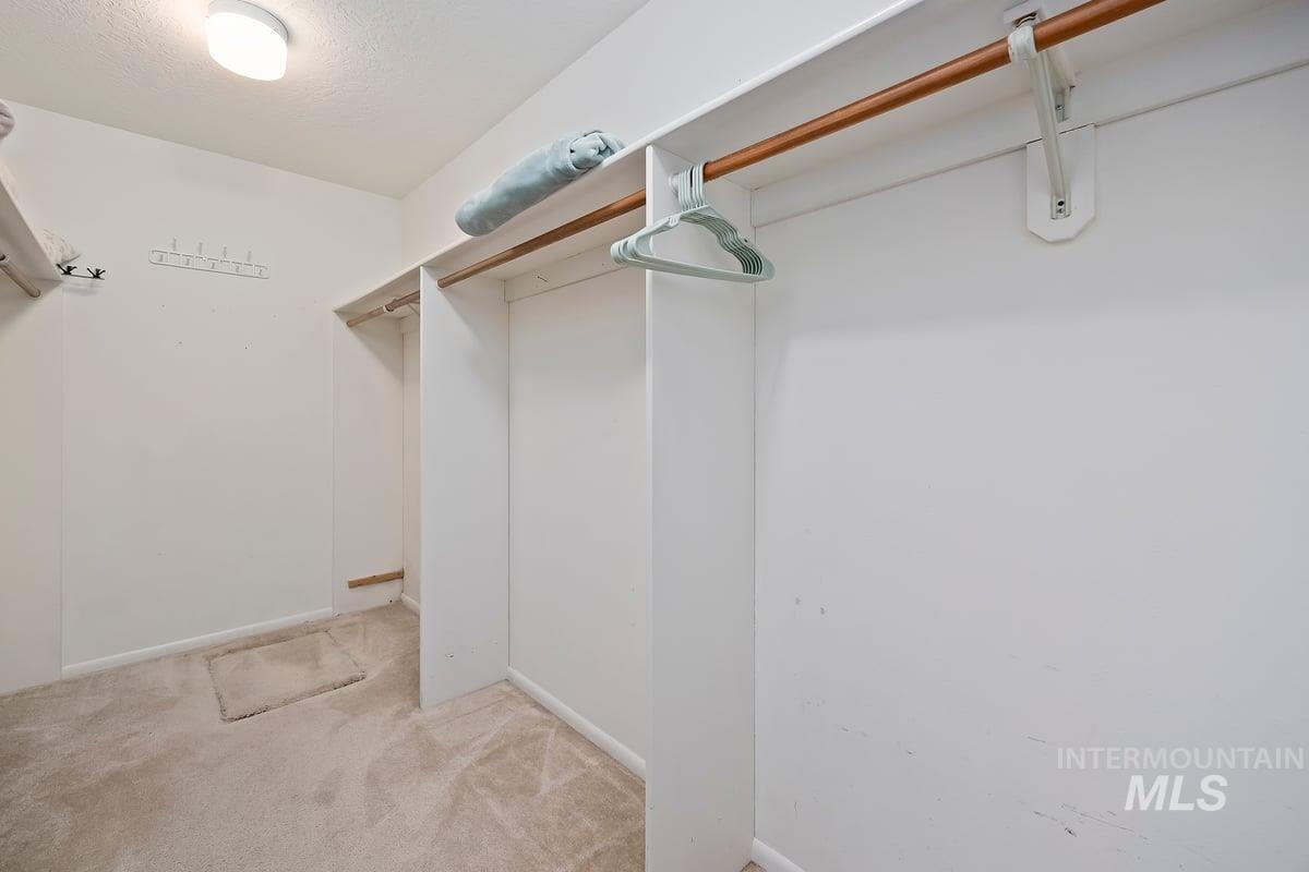 Walk in closet featuring light carpet