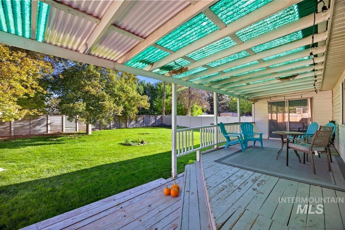 Wooden terrace with a fenced backyard