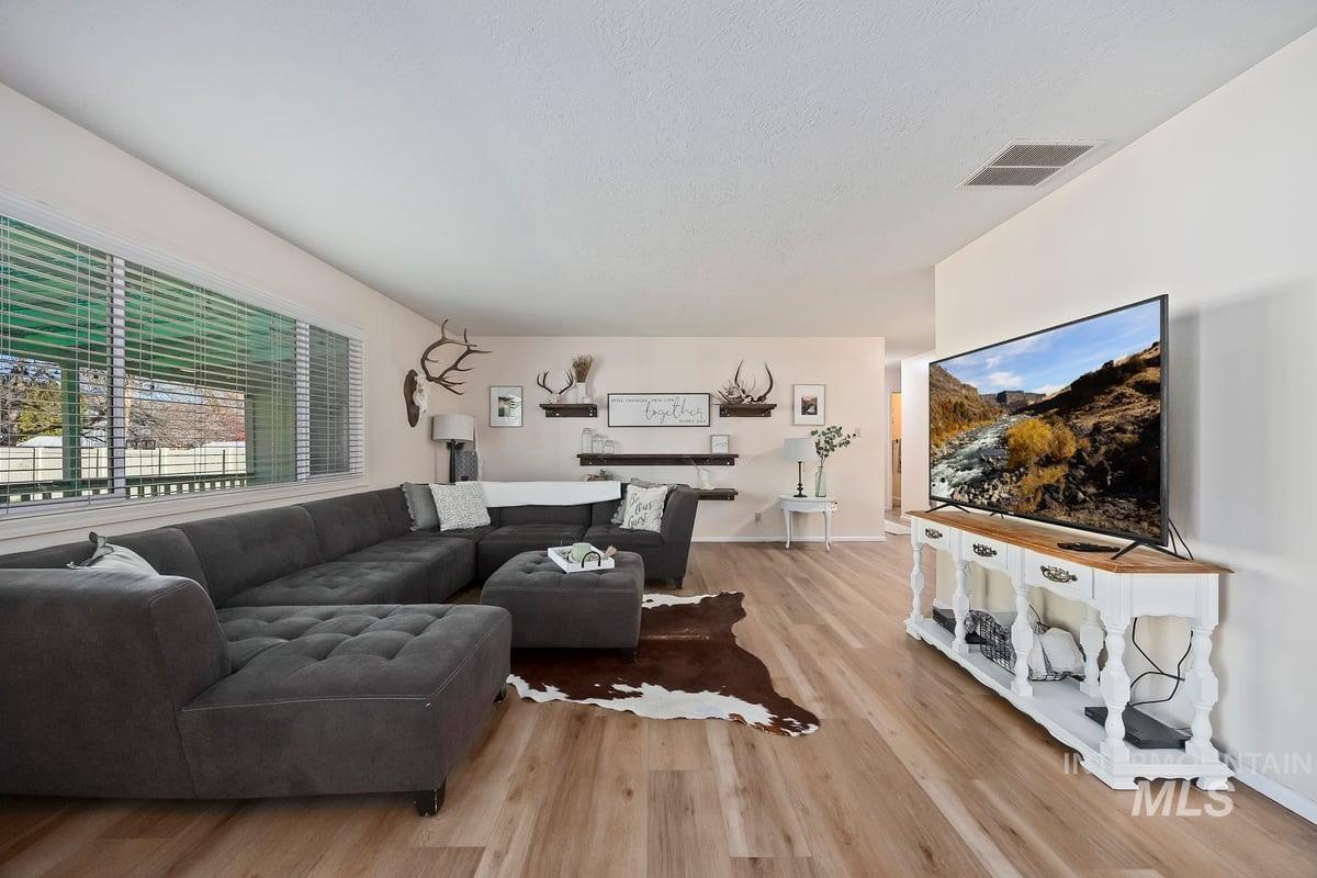 Living room featuring light wood-style flooring and a textured ceiling