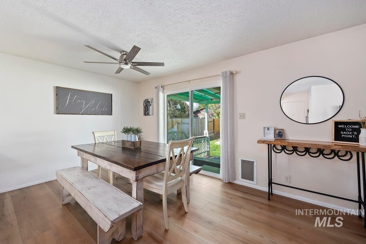 Dining area featuring a textured ceiling, wood finished floors, a ceiling fan, and heating unit