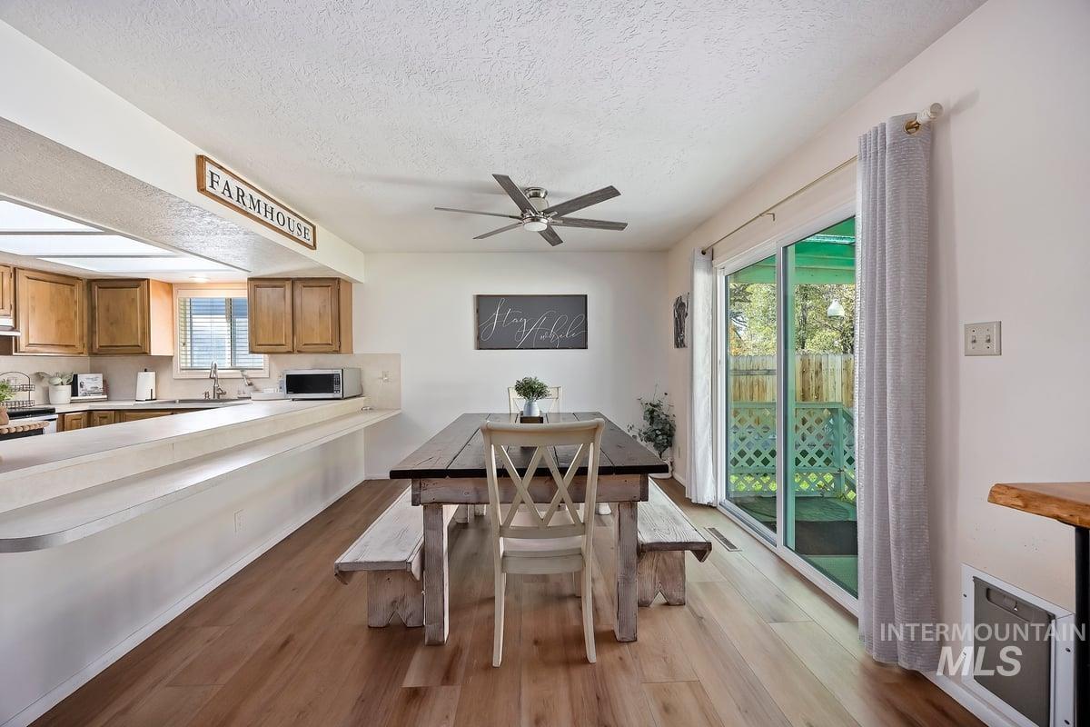 Dining room with dark wood-style flooring, a textured ceiling, and a ceiling fan