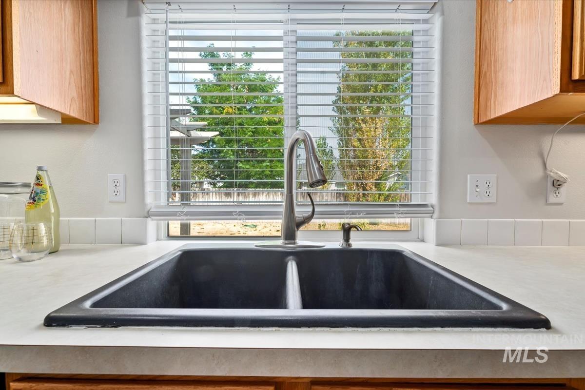 Kitchen view of light countertops and brown cabinets
