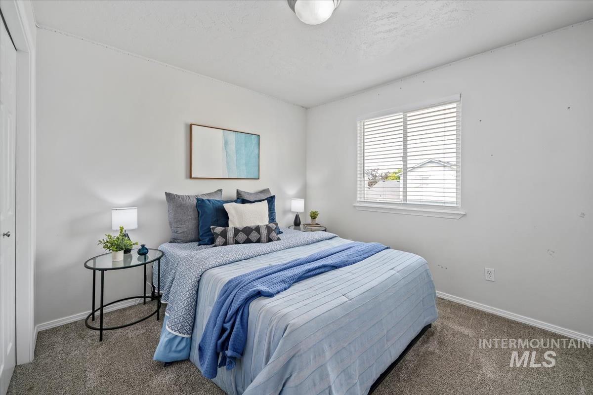 Carpeted bedroom with baseboards and a textured ceiling