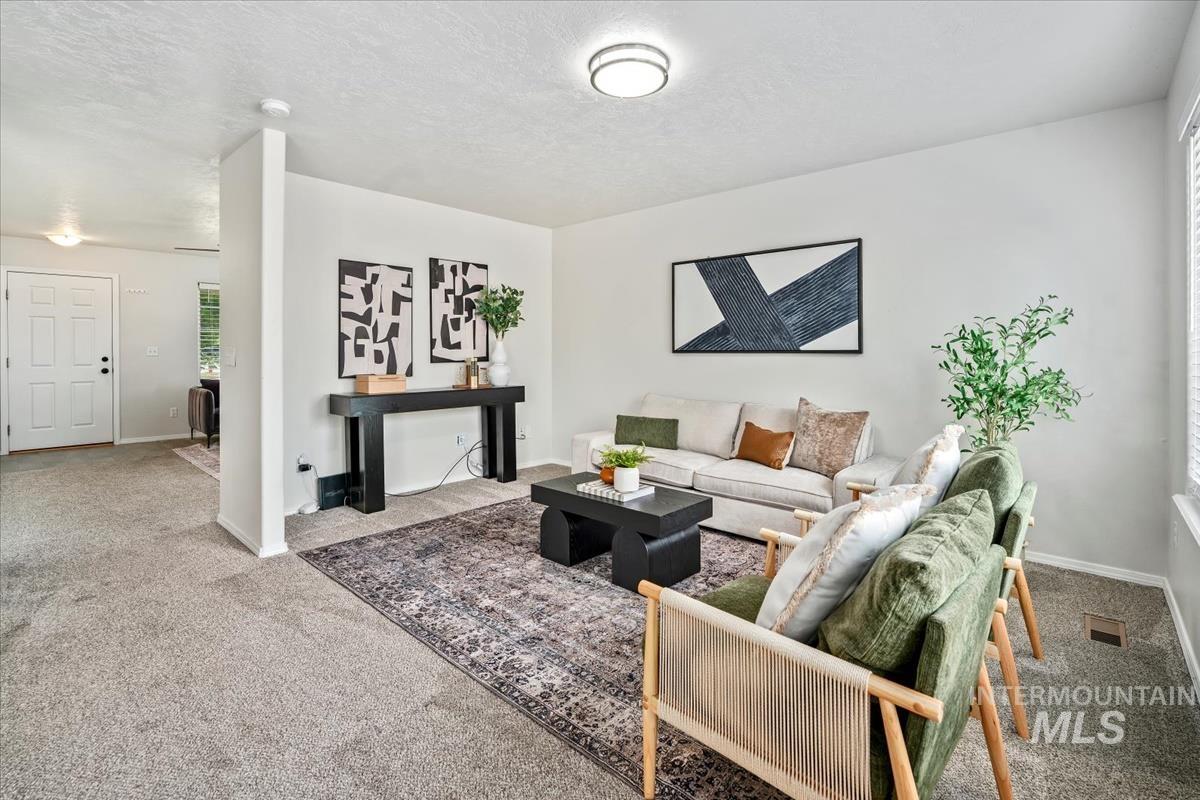 Living area with carpet flooring and a textured ceiling