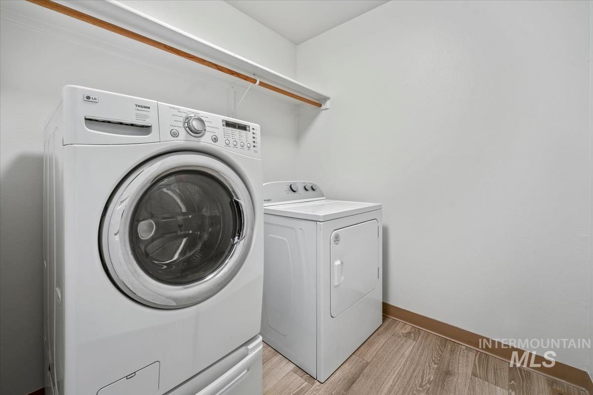 Laundry area featuring light wood finished floors and washer and dryer