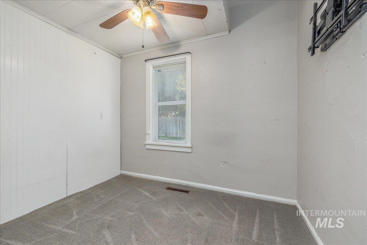 Empty room featuring ornamental molding and carpet floors