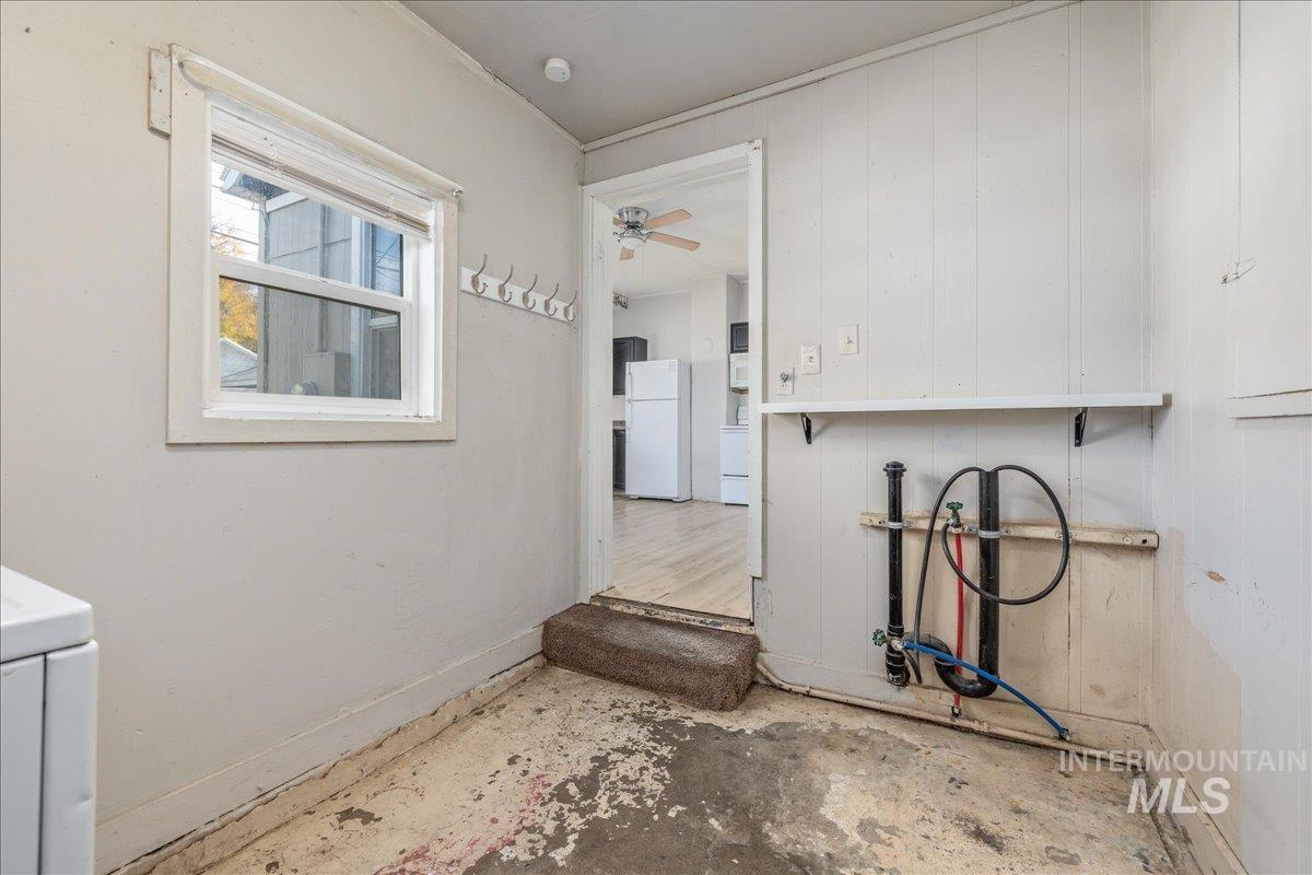 Laundry room with concrete flooring, ceiling fan, and washer / clothes dryer
