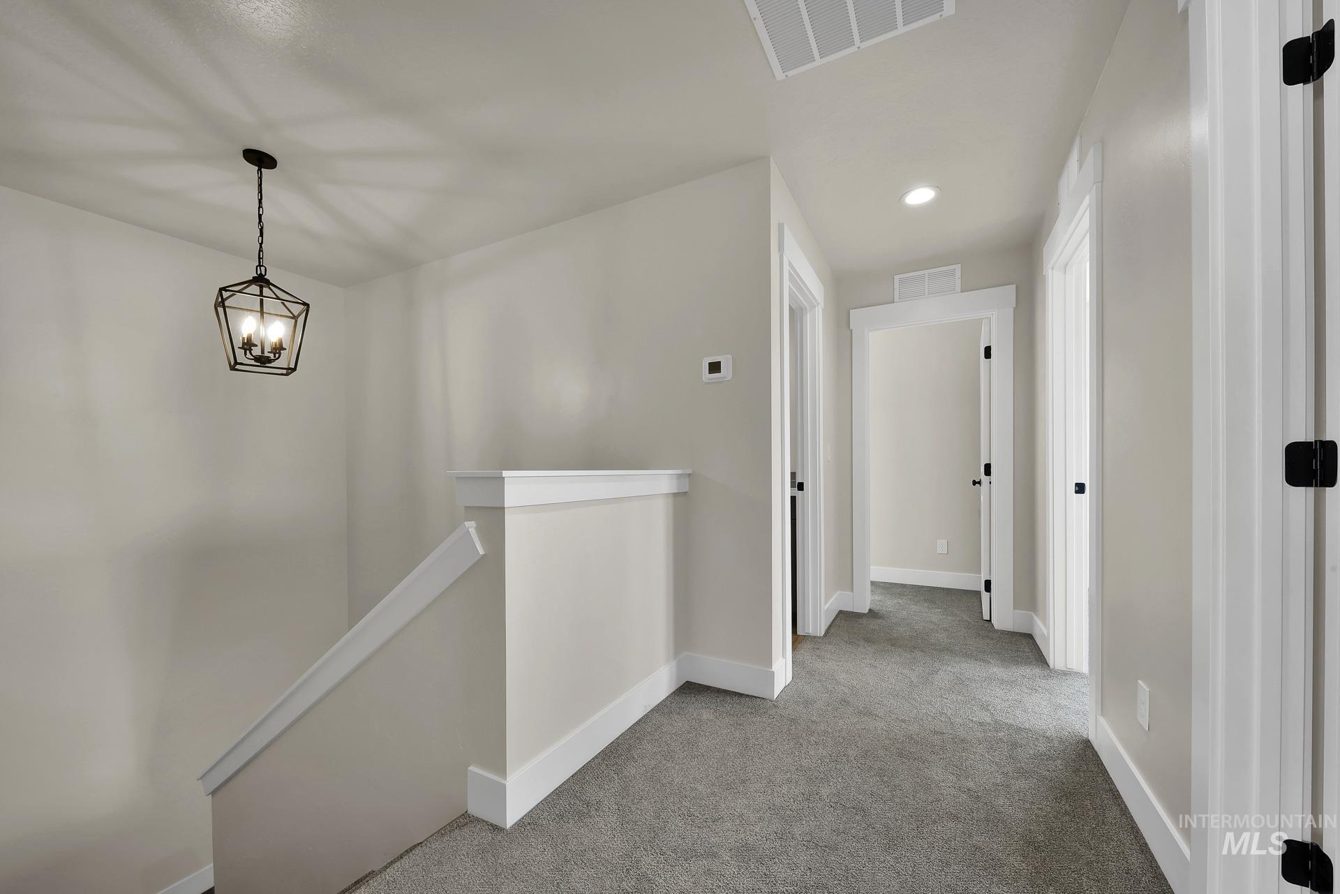 Hallway featuring an upstairs landing, carpet floors, and recessed lighting