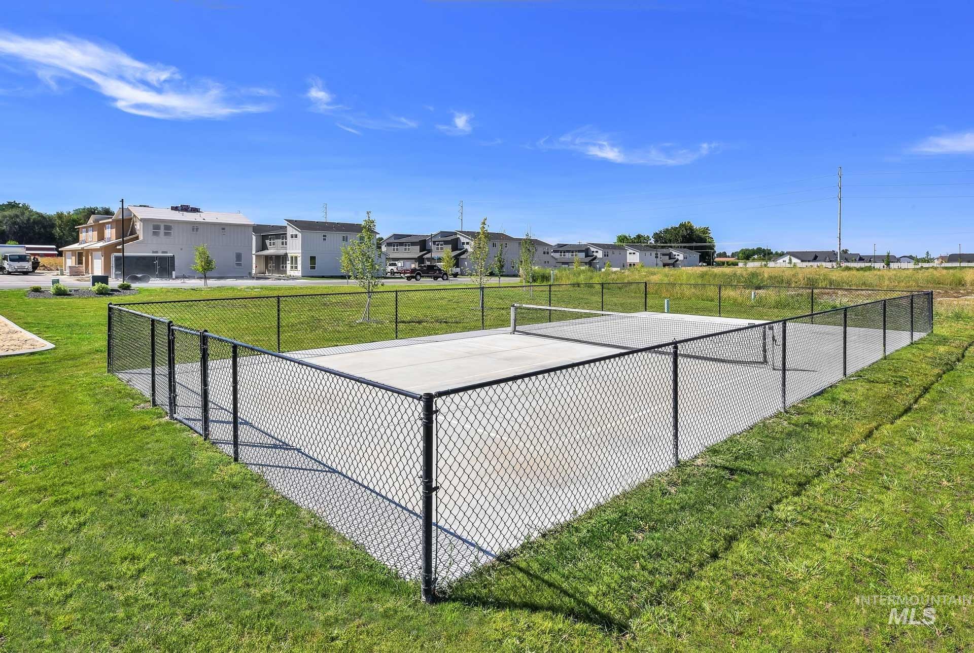 View of tennis court with a residential view