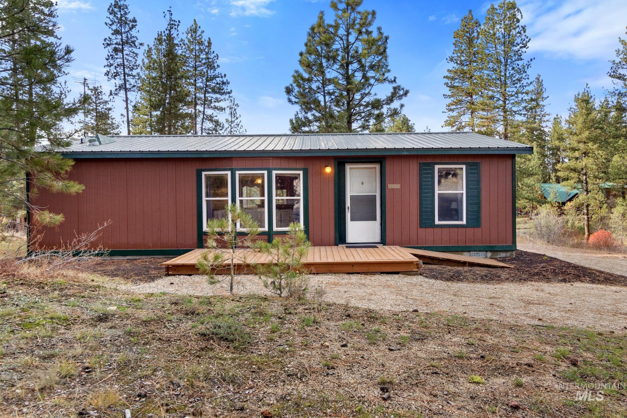 View of front of property with a wooden deck and a metal roof