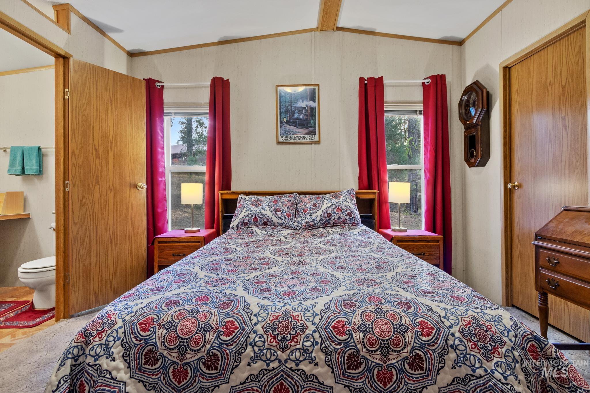 Bedroom with crown molding and lofted ceiling