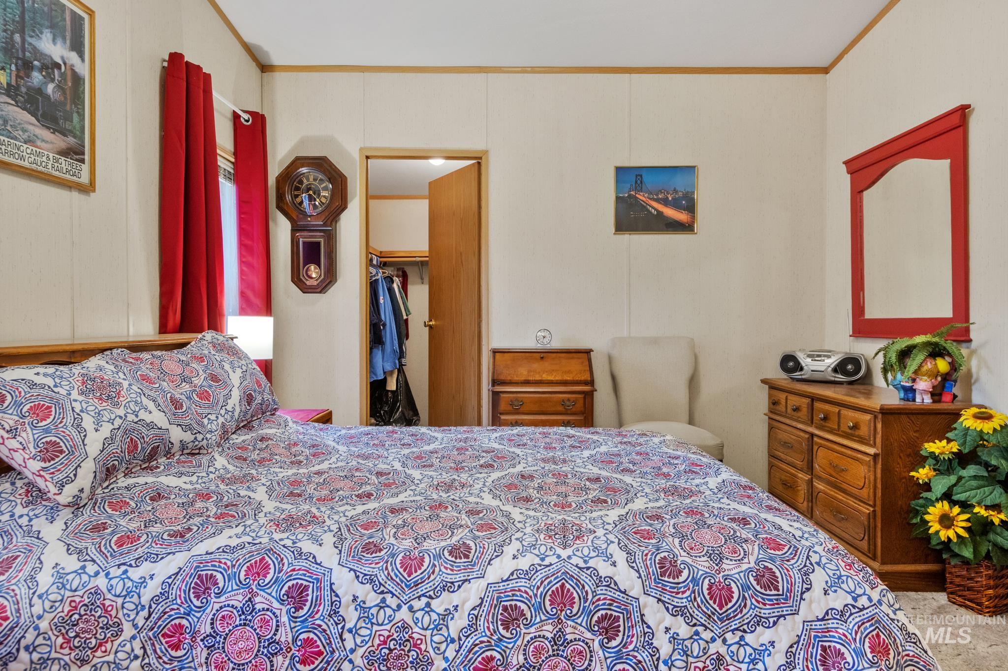 Bedroom with a spacious closet and crown molding