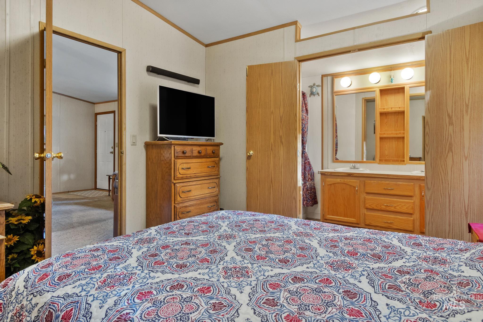 Bedroom with crown molding and carpet floors