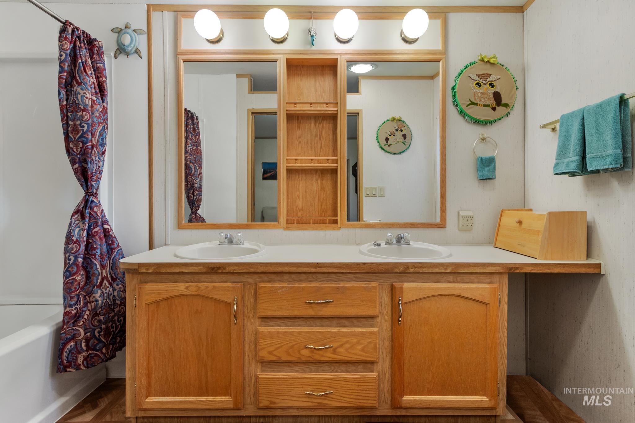 Full bath with double vanity and shower / bath combo