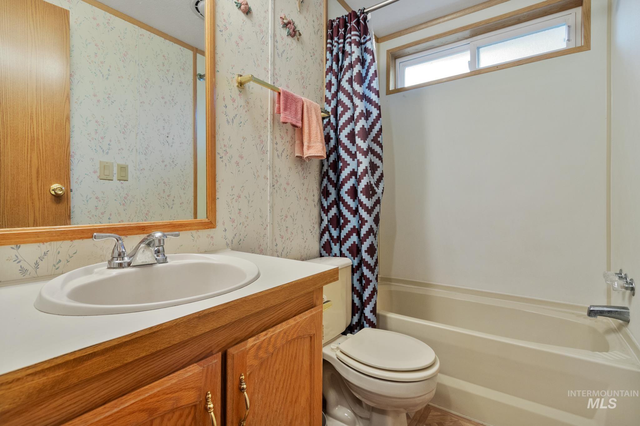 Full bathroom featuring vanity and shower / bath combo with shower curtain