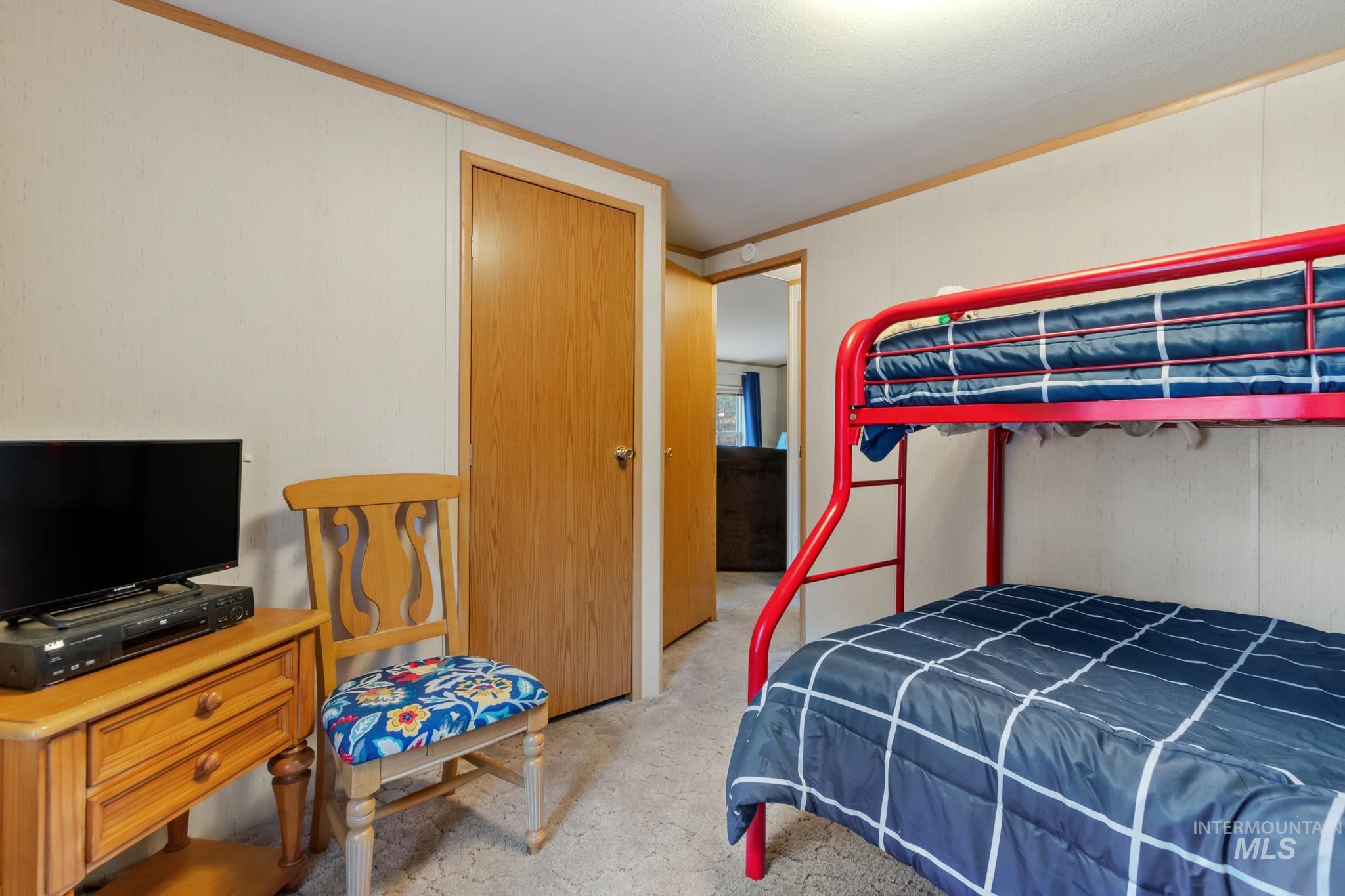 Bedroom featuring crown molding and light carpet