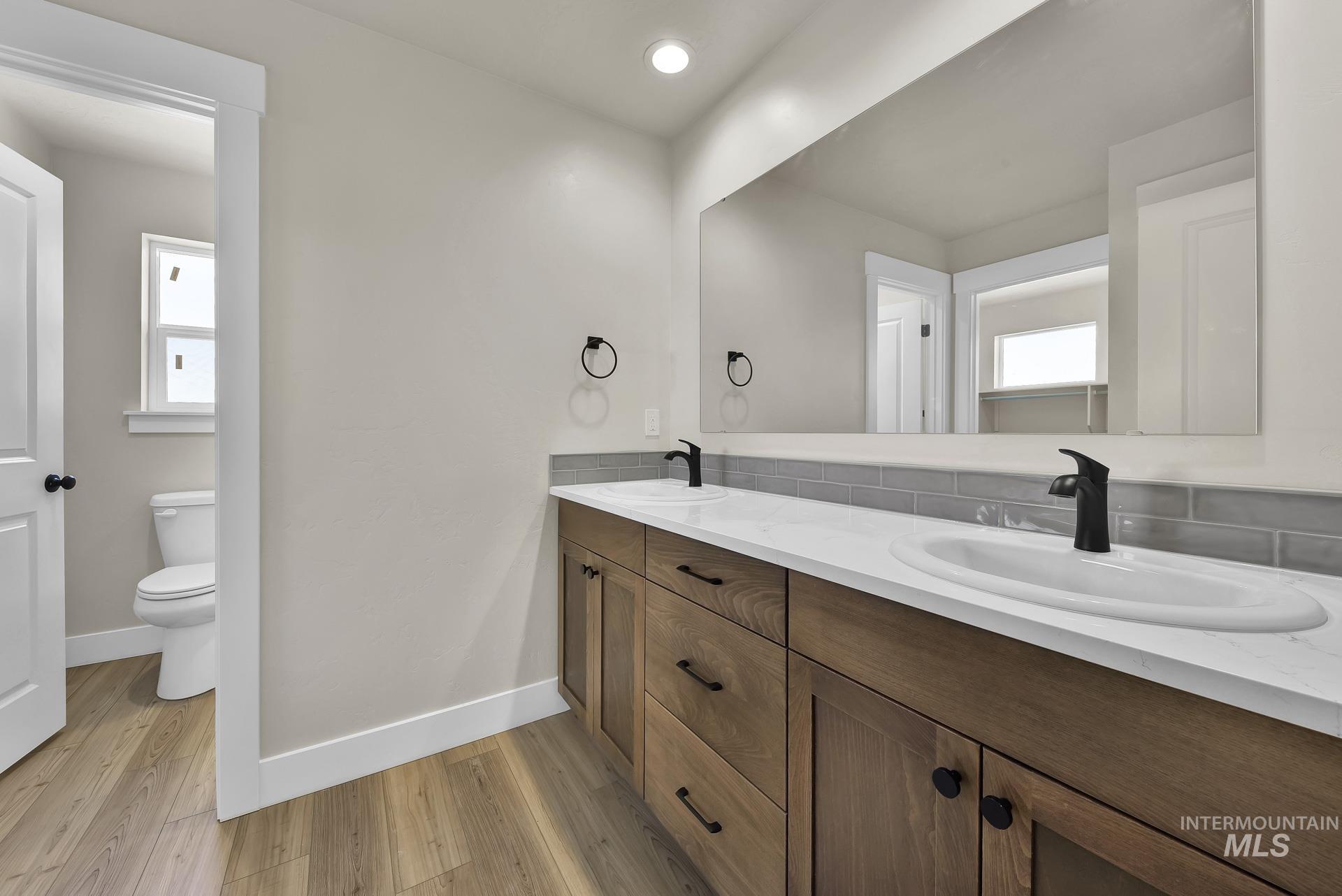 Bathroom featuring double vanity, light wood-style flooring, and recessed lighting
