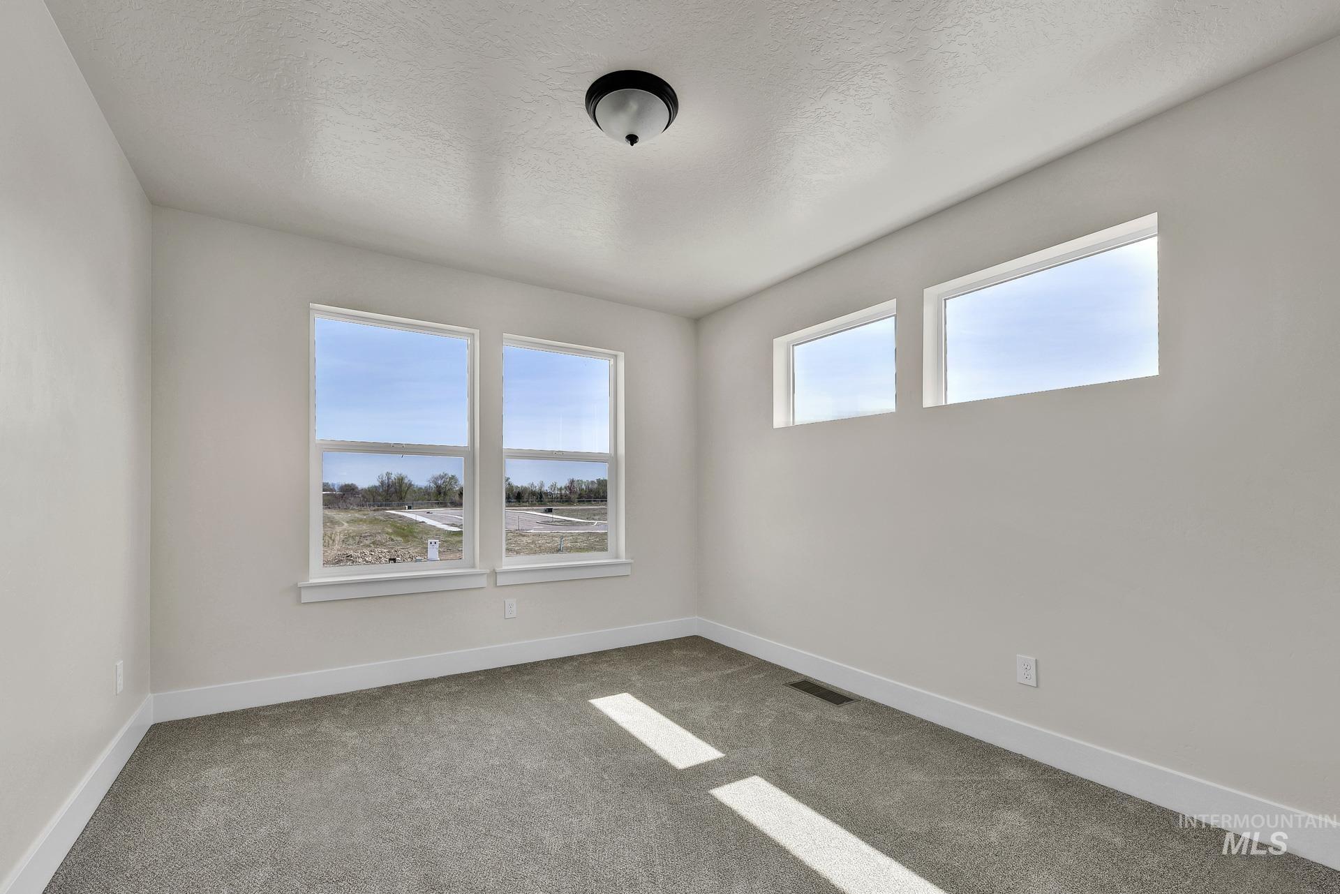 Spare room featuring carpet flooring and a textured ceiling