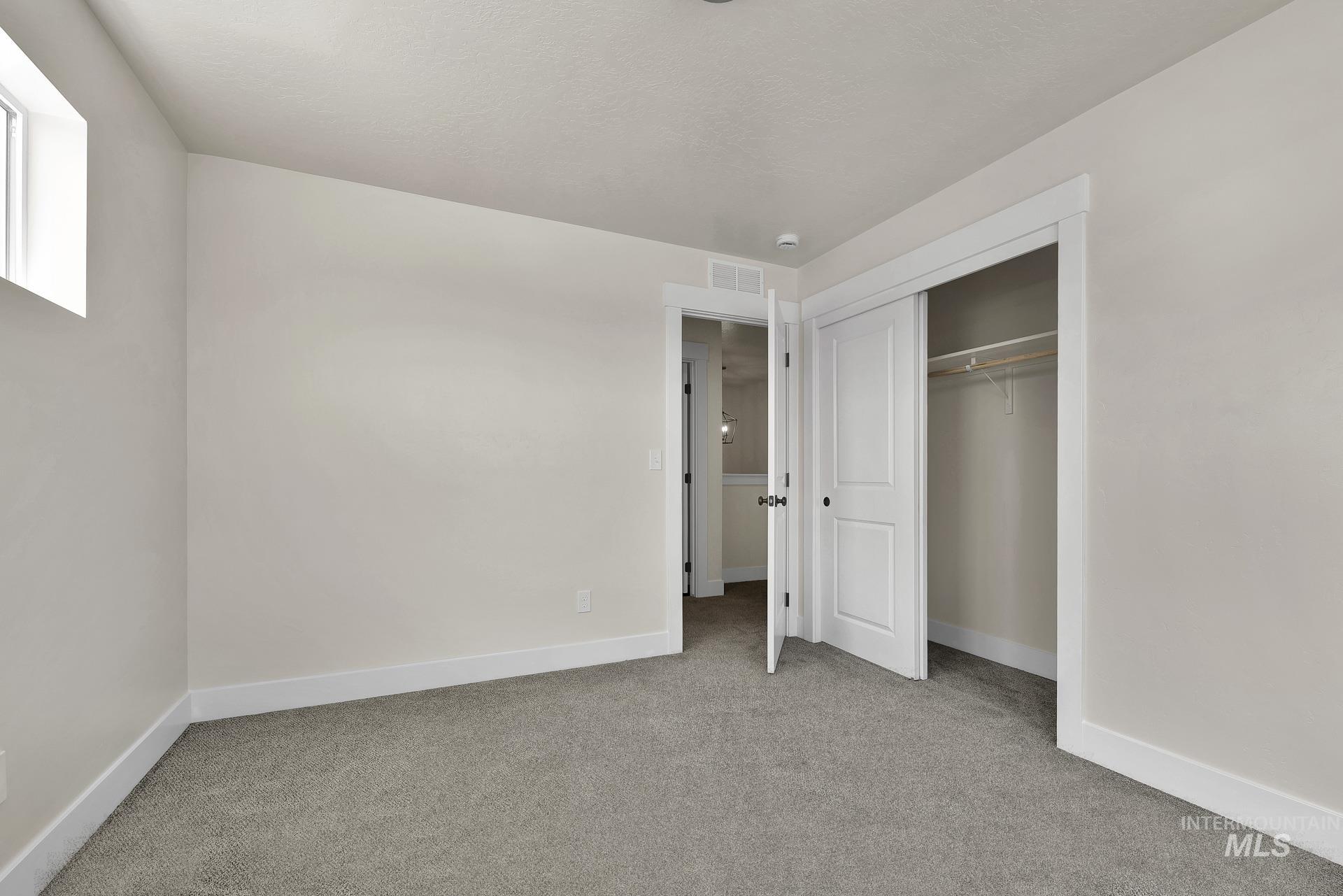 Unfurnished bedroom with light colored carpet and a closet