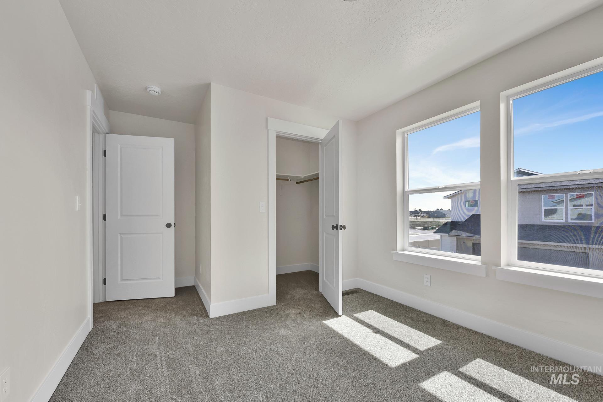 Unfurnished bedroom featuring carpet floors and a spacious closet