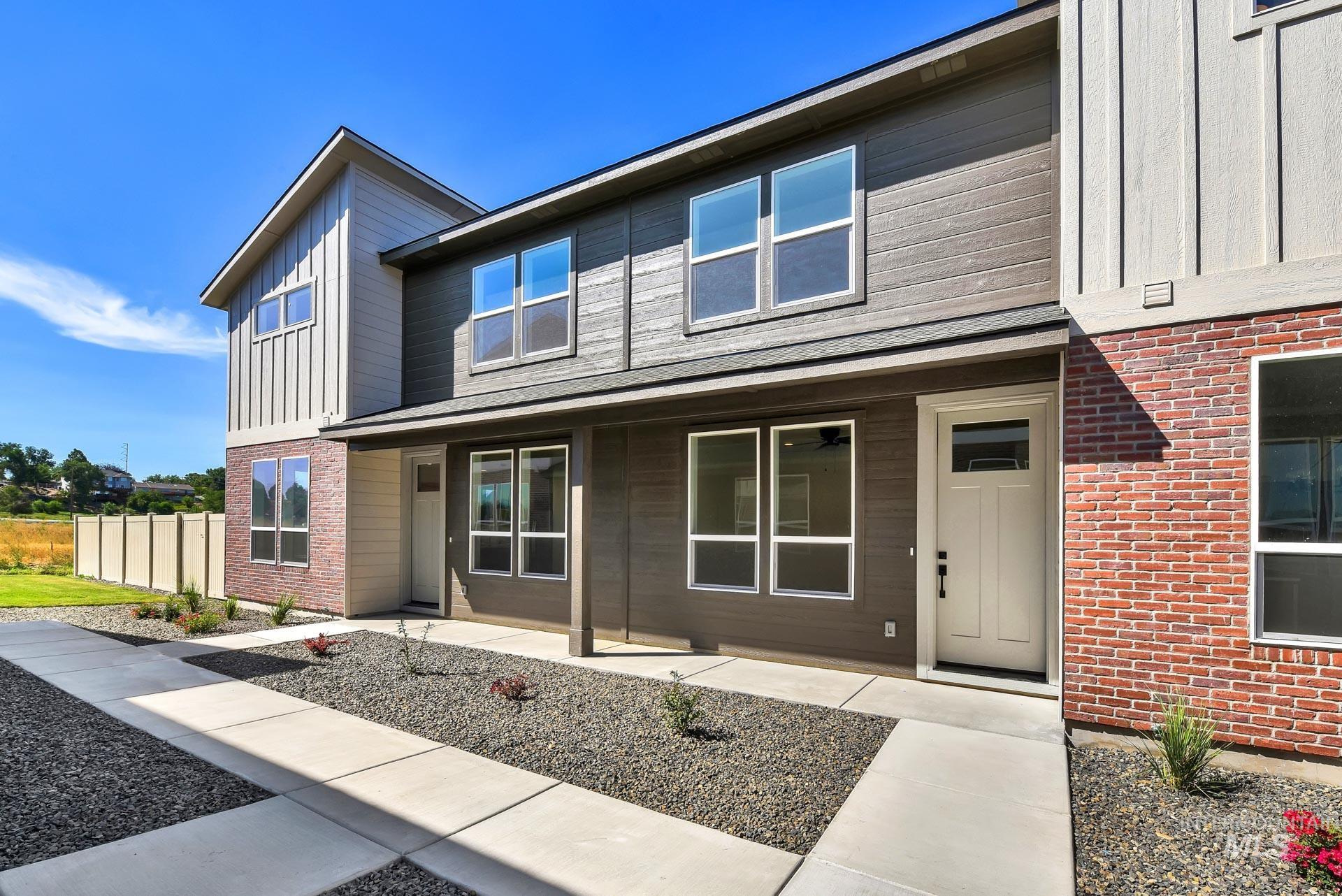 Property entrance featuring board and batten siding and brick siding