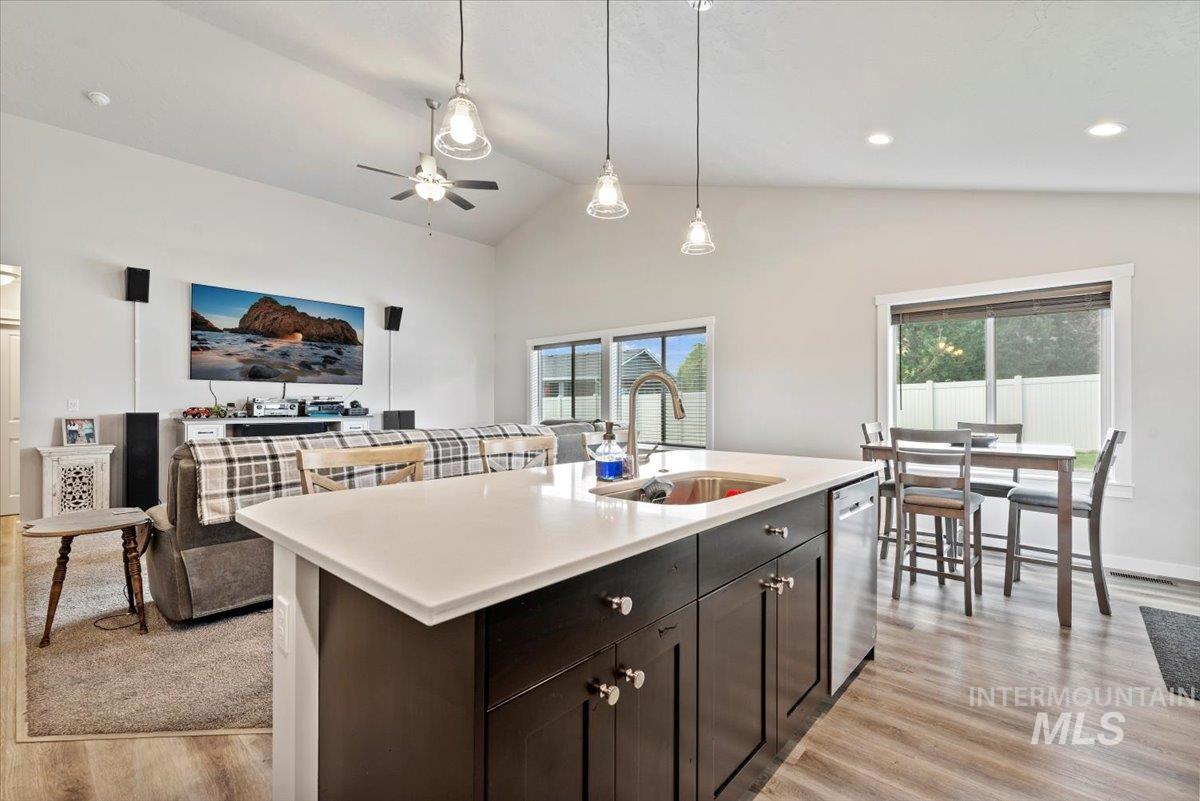 Kitchen featuring light wood-style flooring, light countertops, pendant lighting, open floor plan, and recessed lighting