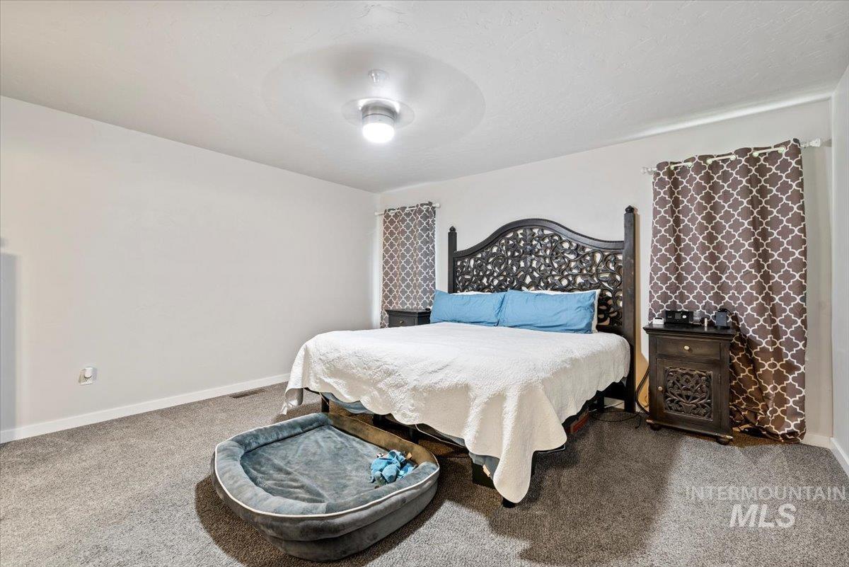 Carpeted bedroom with baseboards and a ceiling fan