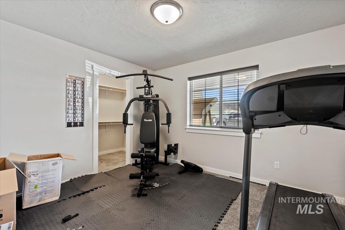Workout area with a textured ceiling and baseboards