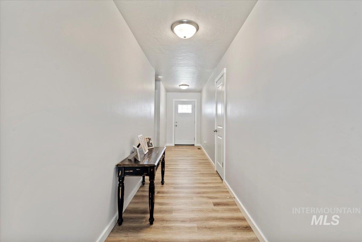Hallway featuring light wood-type flooring and a textured ceiling