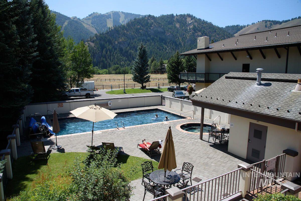 View of swimming pool with a mountain view, a patio, and outdoor dining area