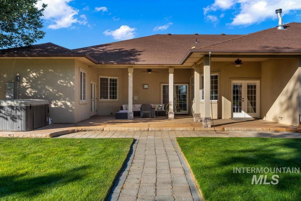 Back of property with a patio, stucco siding, ceiling fan, and a hot tub