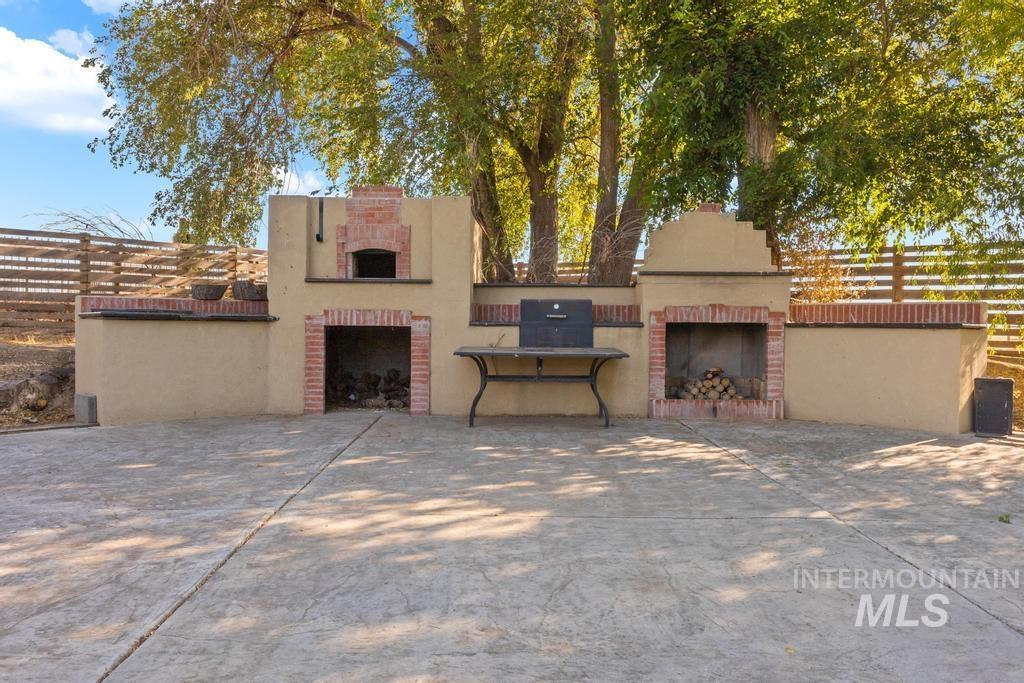 View of front of property featuring an outdoor brick fireplace and stucco siding
