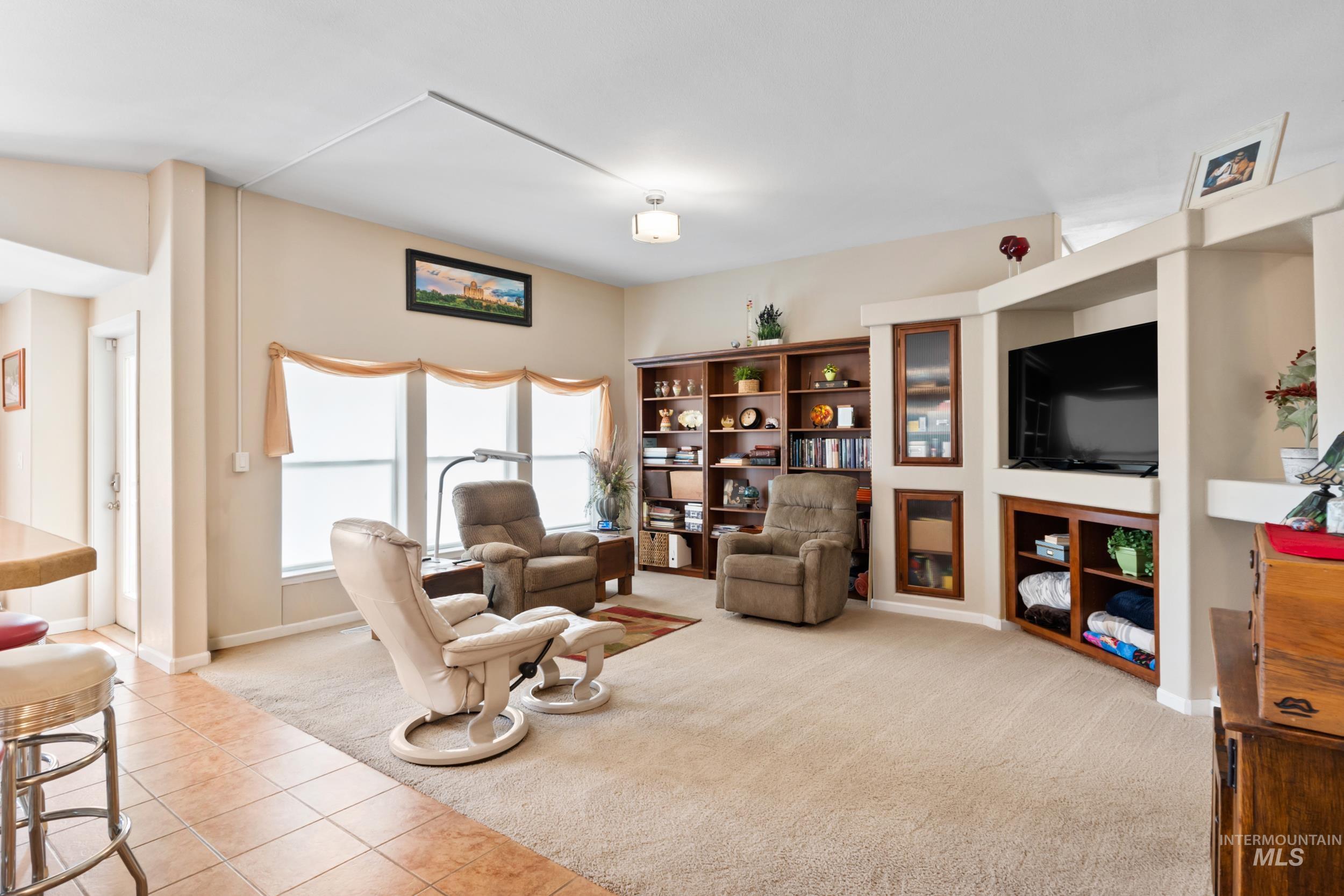 Living area featuring light colored carpet and light tile patterned flooring