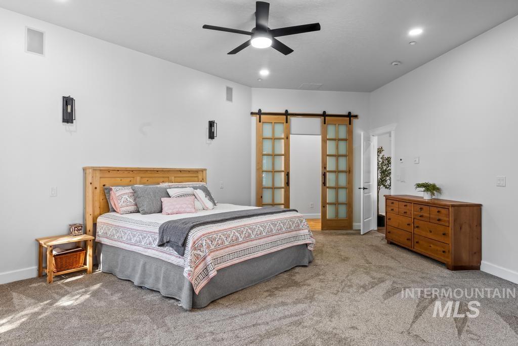 Bedroom featuring a barn door, carpet flooring, ceiling fan, and recessed lighting