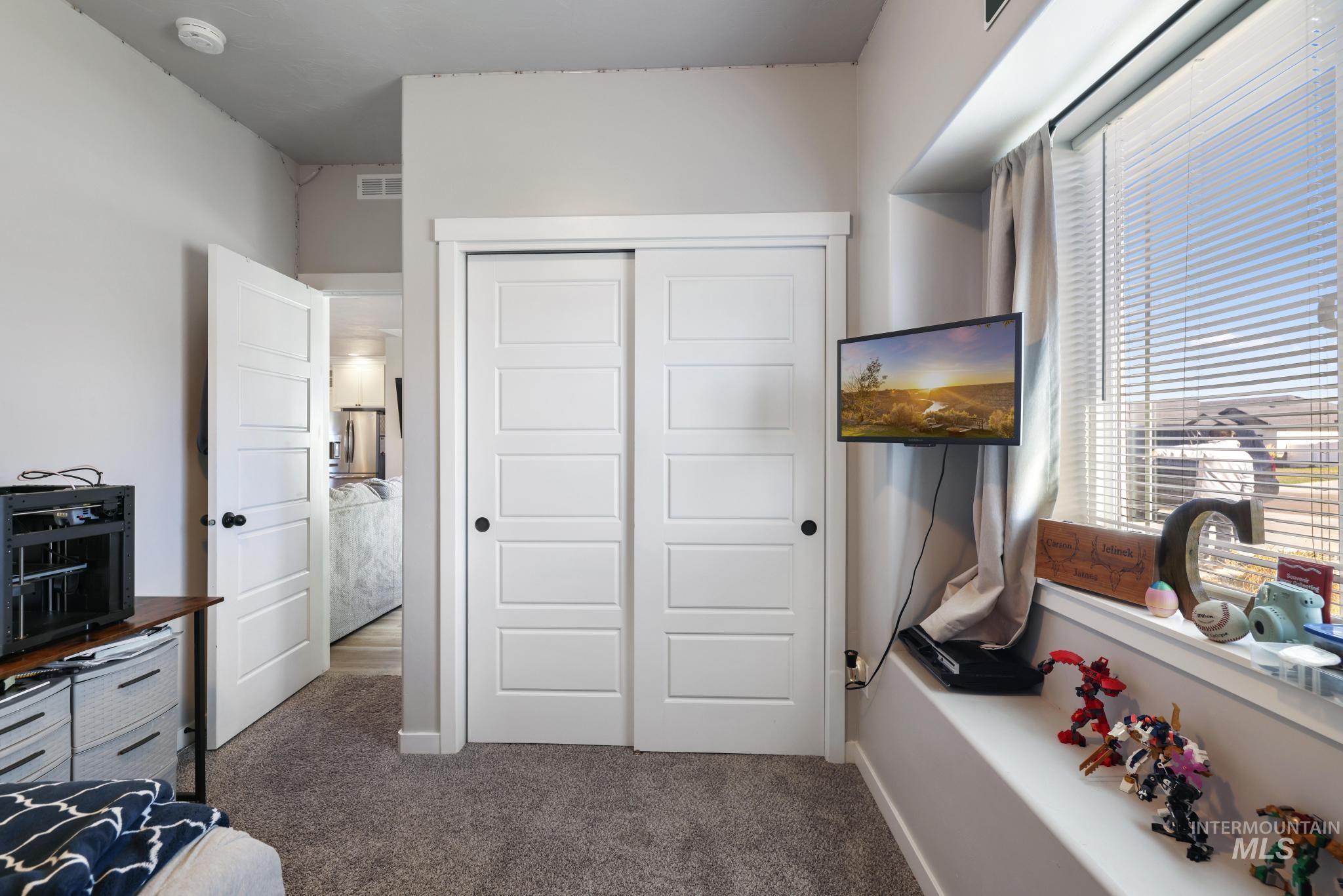 Bedroom featuring dark colored carpet and a closet
