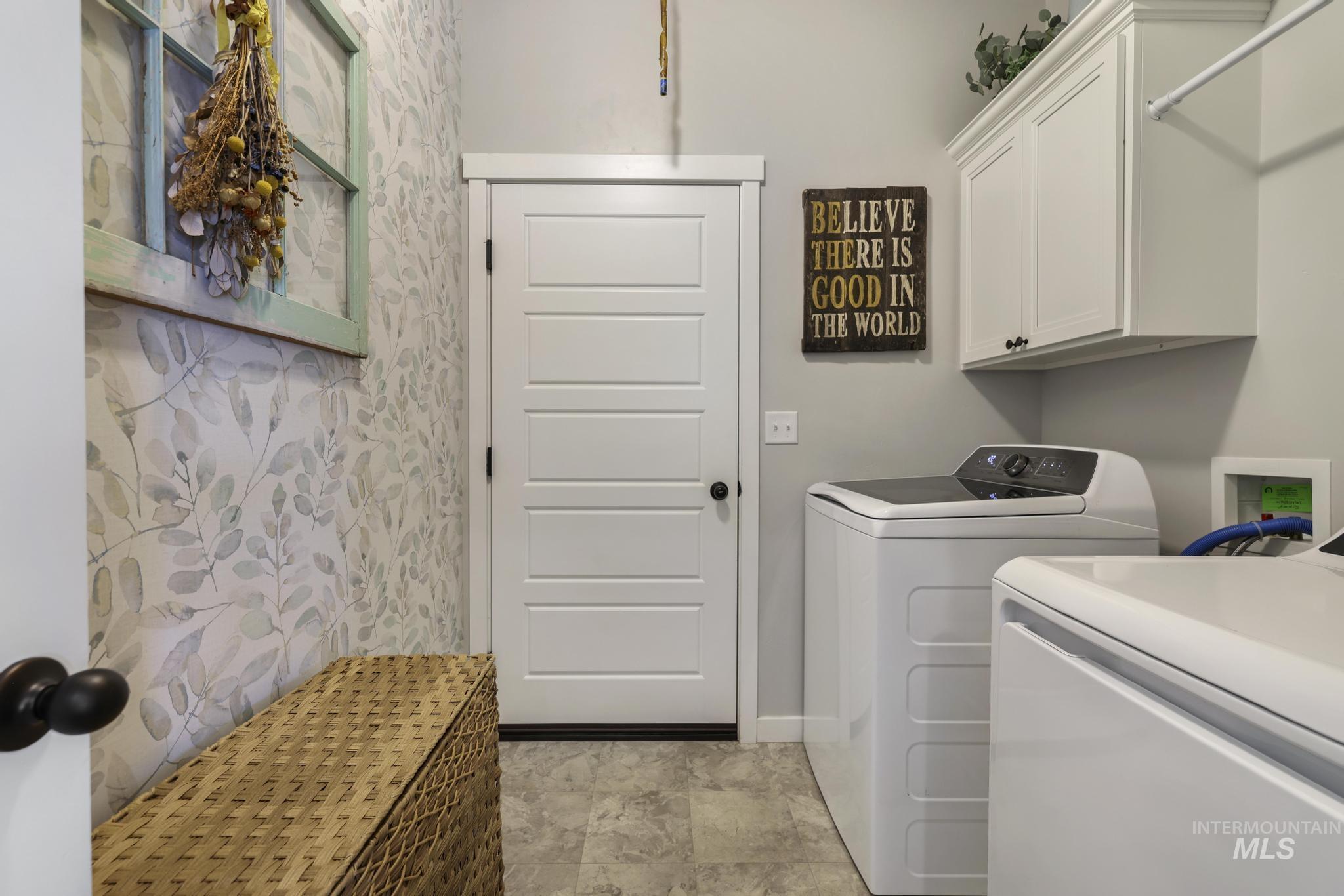Laundry area featuring independent washer and dryer and cabinet space