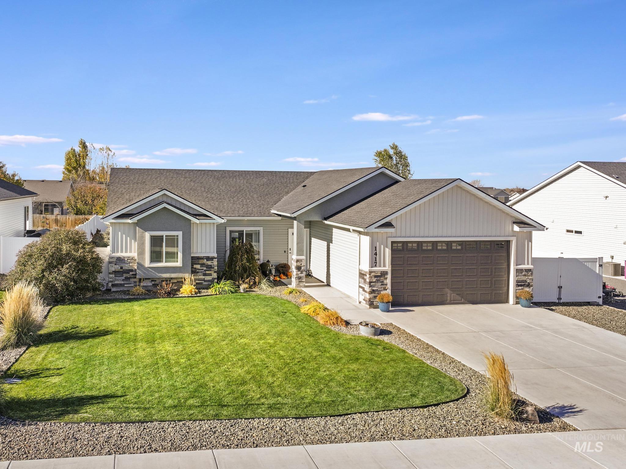View of front of house featuring stone siding, roof with shingles, and board and batten siding