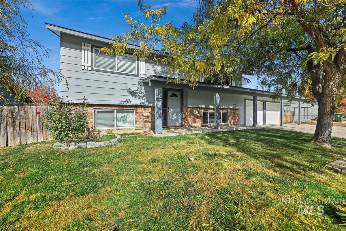 View of front of property featuring brick siding, driveway, and a garage