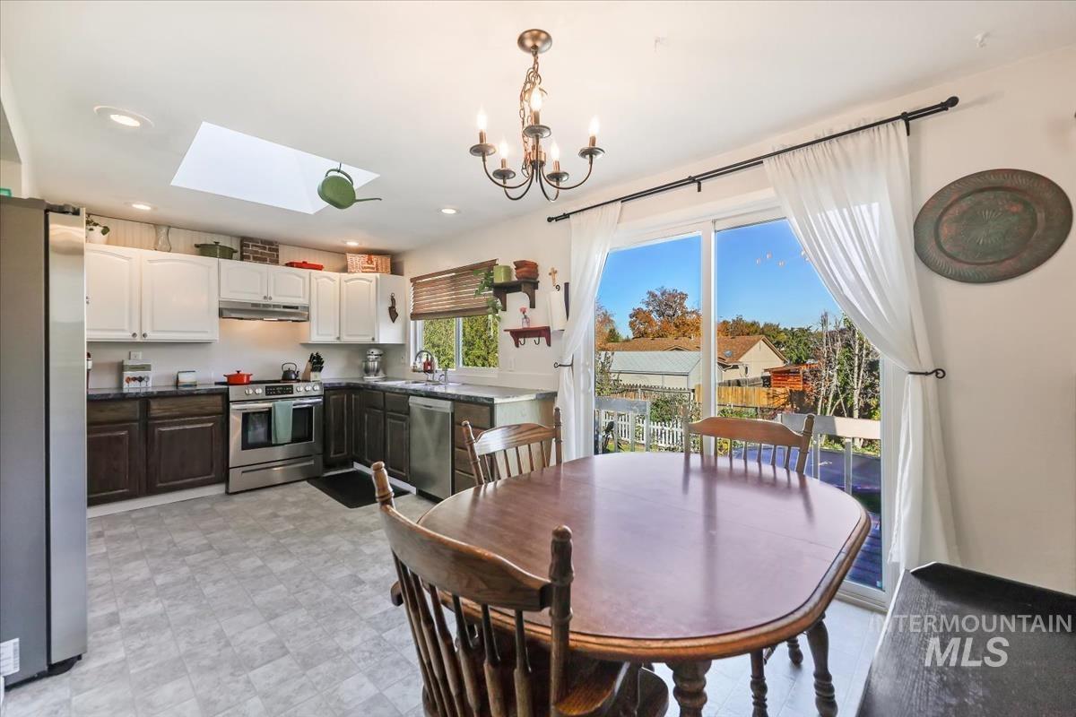 Dining area featuring a skylight, a chandelier, and recessed lighting
