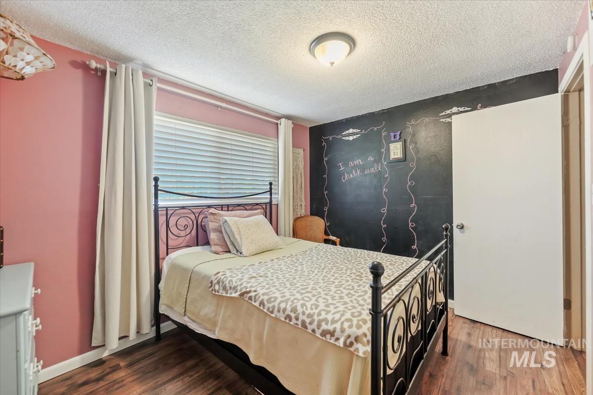 Bedroom featuring a textured ceiling and wood finished floors