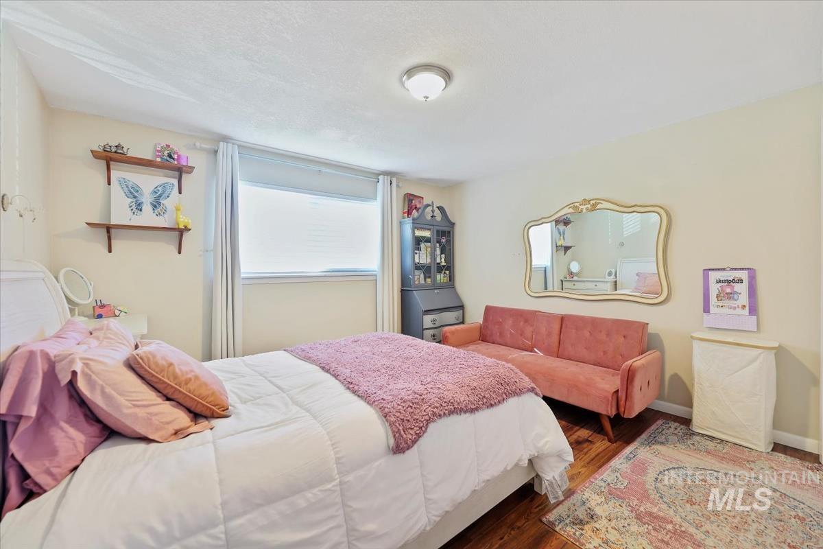Bedroom featuring wood finished floors and baseboards