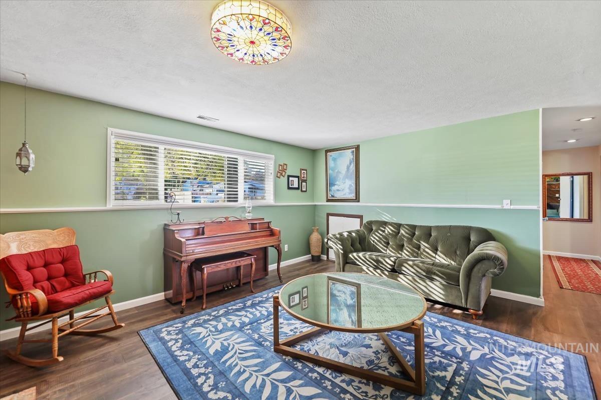 Living area with dark wood-type flooring and a textured ceiling