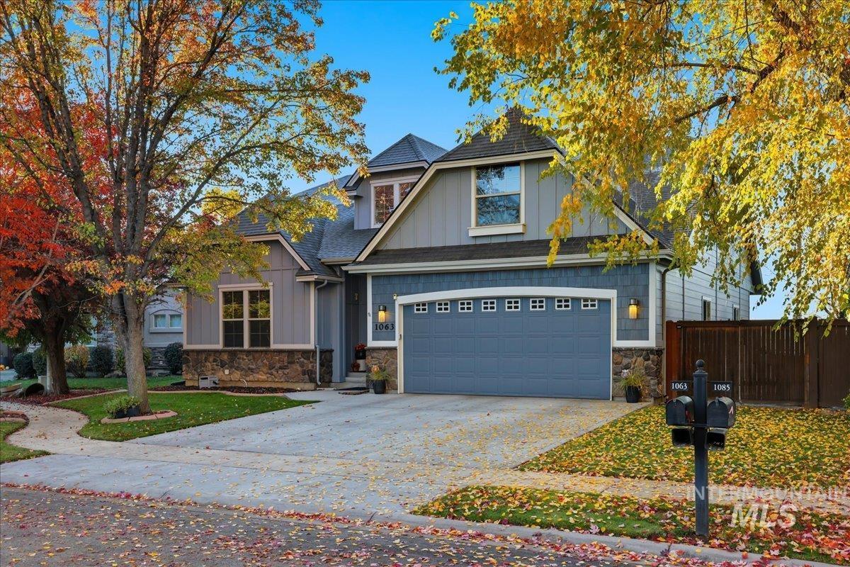 Craftsman house featuring board and batten siding, stone siding, and concrete driveway
